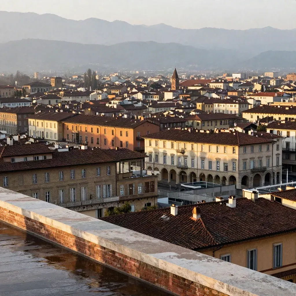 Torino al mattino dopo la pioggia, arcate, tetti e Alpi lontane in luce dorata.